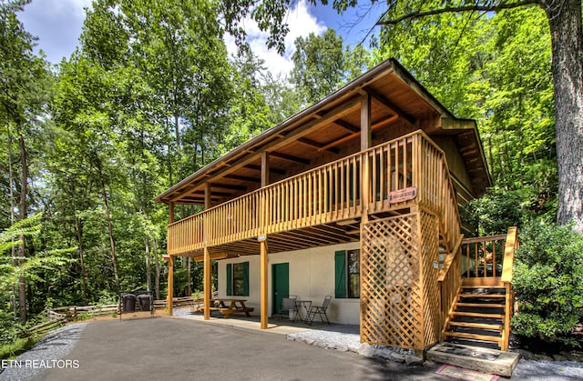 rear view of property with a deck and a patio