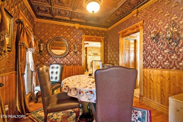 dining area with hardwood / wood-style flooring and crown molding