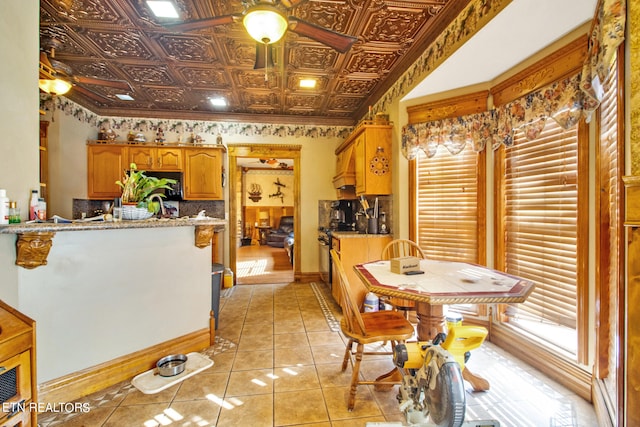 dining room with ornamental molding, light tile patterned flooring, and ceiling fan