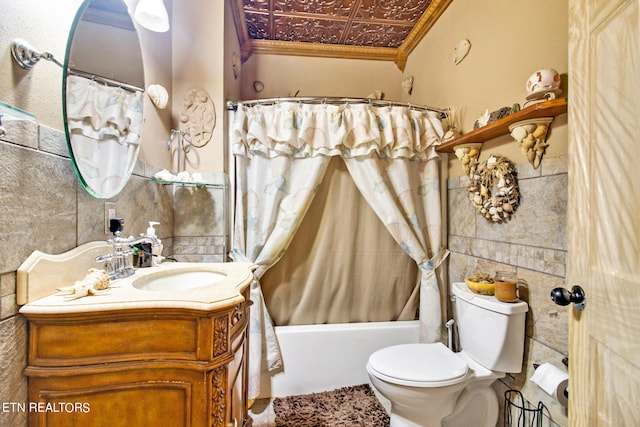 full bathroom with tile walls, shower / bath combo, toilet, vanity, and ornamental molding