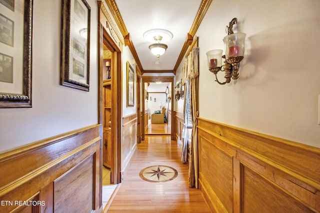 hall with light hardwood / wood-style flooring and ornamental molding