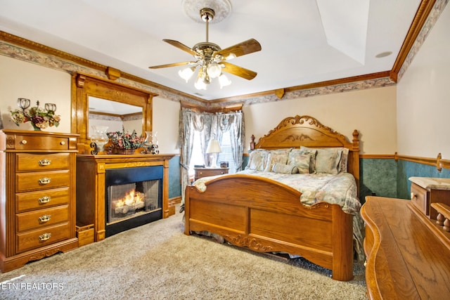 carpeted bedroom featuring crown molding and ceiling fan