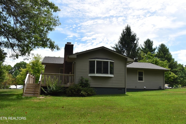 rear view of house with a deck and a lawn