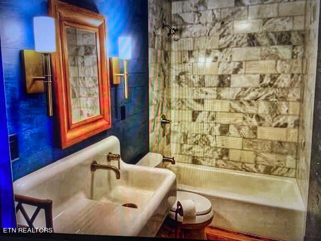 bathroom featuring shower / bathing tub combination and toilet