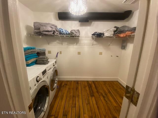 laundry area with dark hardwood / wood-style flooring, an inviting chandelier, and independent washer and dryer