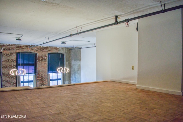 spare room with parquet flooring, pool table, and brick wall