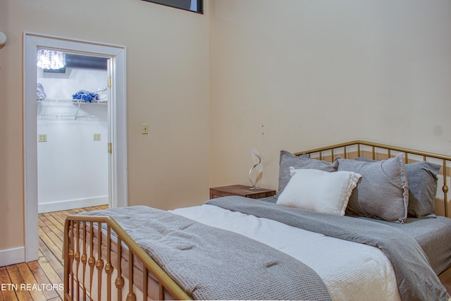 bedroom featuring a spacious closet, a closet, and hardwood / wood-style flooring