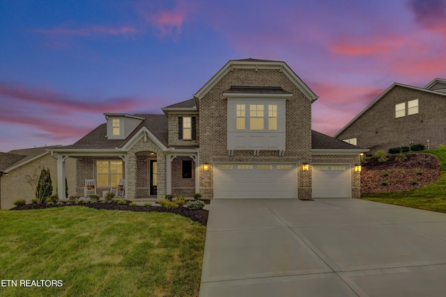 view of front of property featuring a garage and a lawn