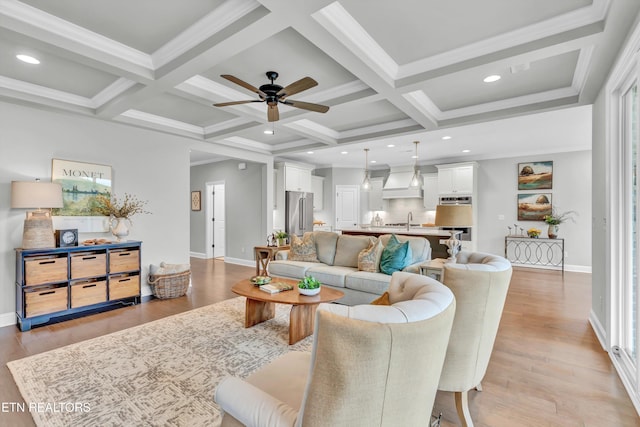 living room with light hardwood / wood-style floors, beamed ceiling, coffered ceiling, and ceiling fan