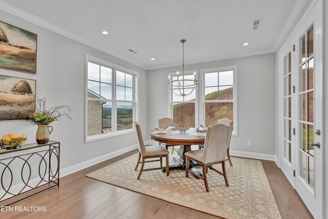 dining room featuring crown molding, a chandelier, and wood-type flooring