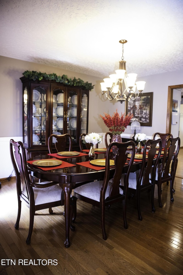 dining space featuring a chandelier, hardwood / wood-style floors, and a textured ceiling