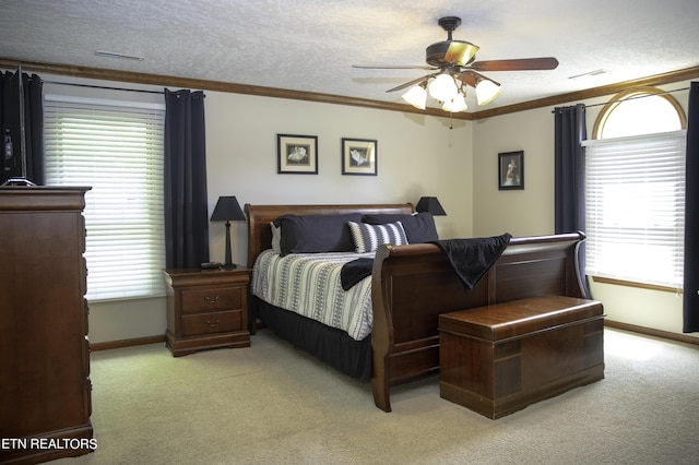 bedroom with ceiling fan, light colored carpet, ornamental molding, and a textured ceiling