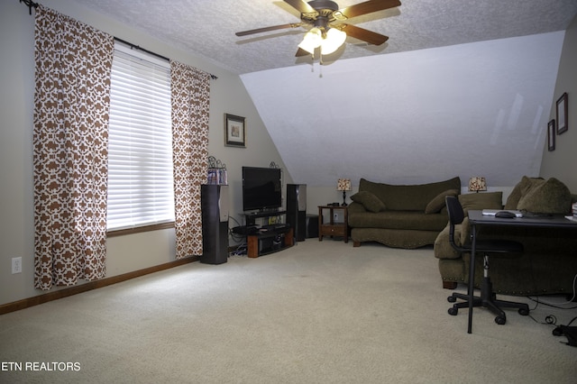 home office with vaulted ceiling, carpet, ceiling fan, and a textured ceiling