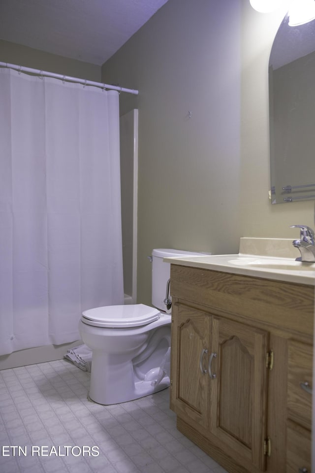 bathroom featuring vanity, curtained shower, and toilet