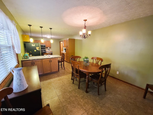 dining room featuring plenty of natural light, a chandelier, and a textured ceiling