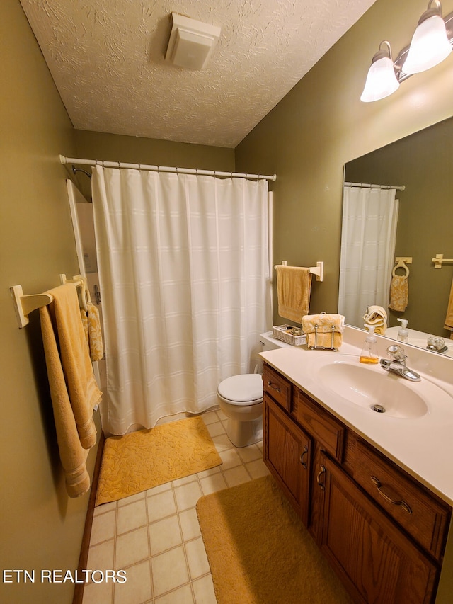 bathroom featuring vanity, toilet, and a textured ceiling