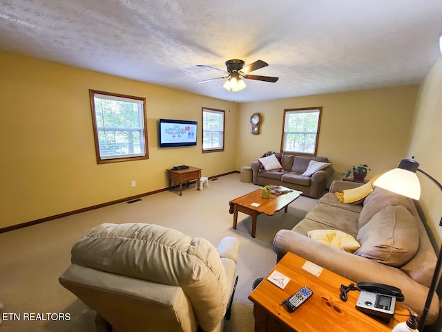 living room with ceiling fan, plenty of natural light, and carpet