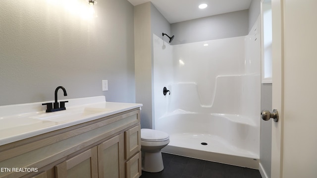 bathroom with toilet, vanity, and a shower