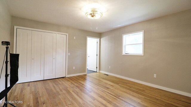 unfurnished bedroom featuring a closet and light wood-type flooring