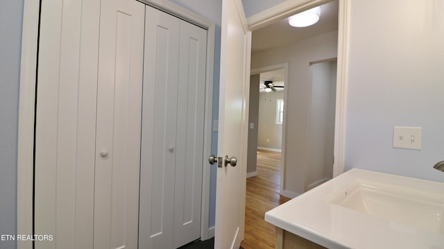 bathroom with ceiling fan, sink, and hardwood / wood-style floors