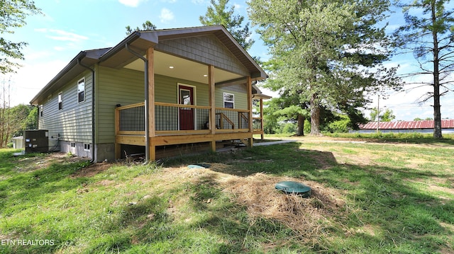 view of front of home with a front lawn and central AC unit