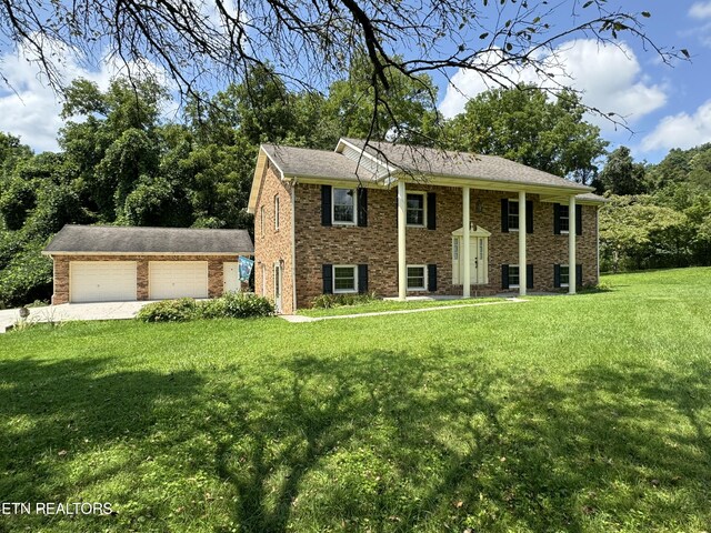 raised ranch featuring a front lawn and a garage