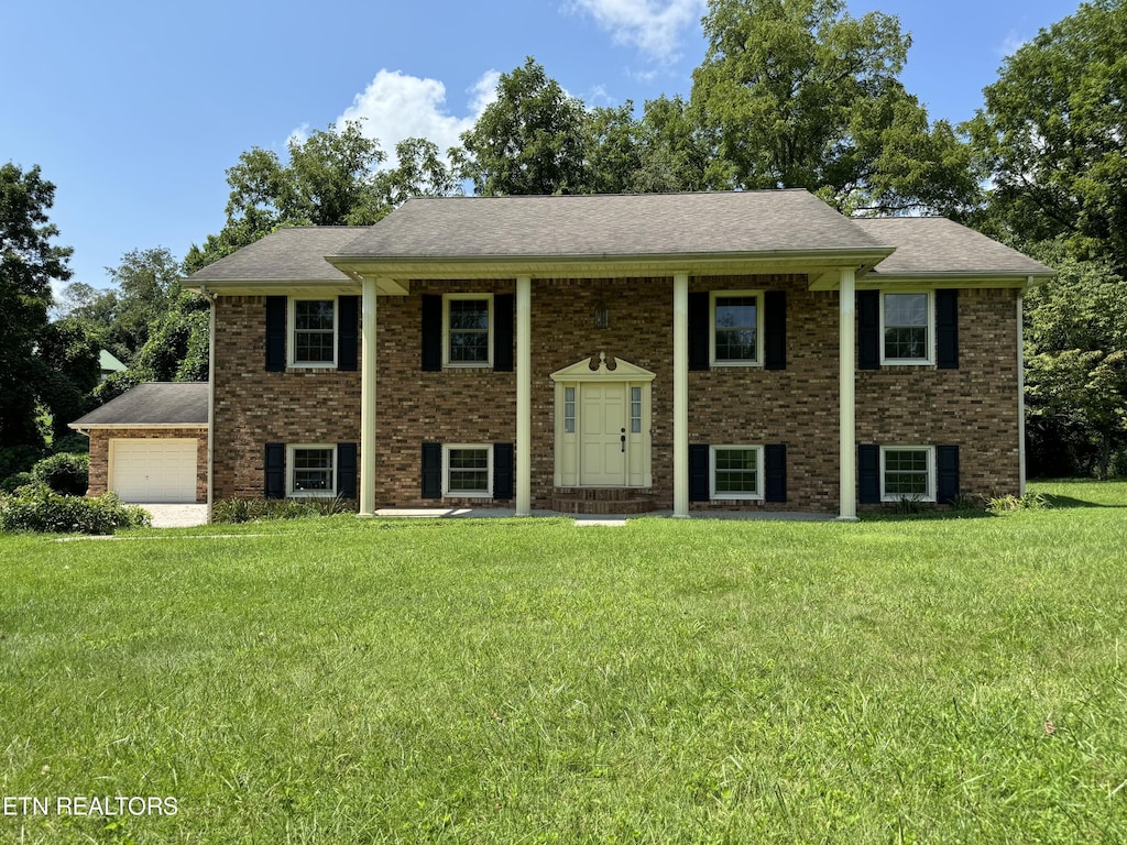 bi-level home with a garage and a front lawn