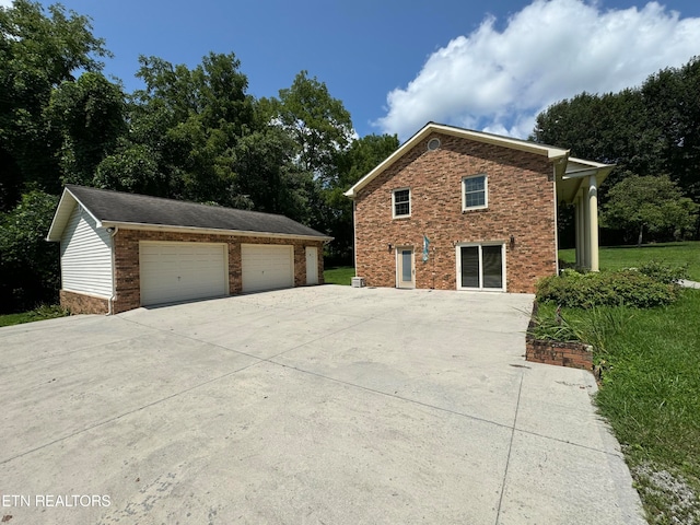 view of side of property featuring a garage, an outbuilding, and a yard