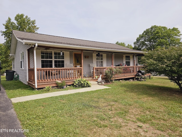 ranch-style home featuring a front lawn and covered porch