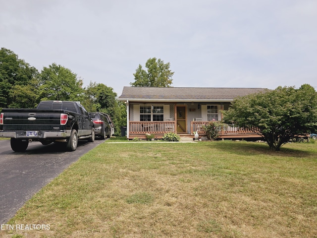 ranch-style home featuring covered porch and a front yard