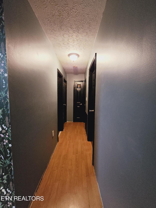 hallway featuring a textured ceiling and light wood-type flooring