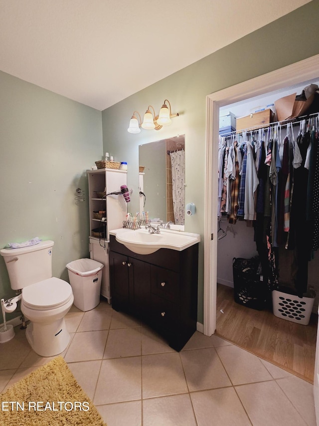 bathroom featuring toilet, tile patterned floors, and vanity