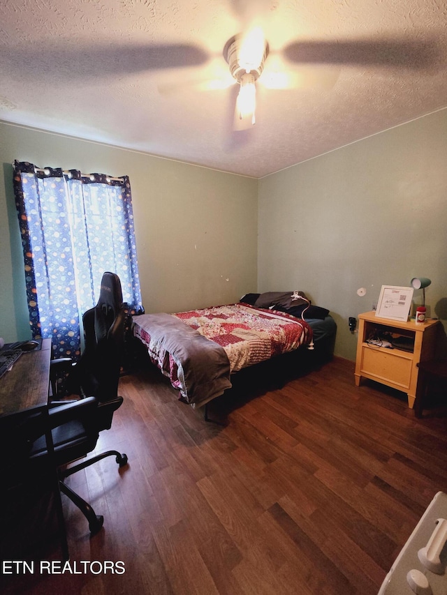 bedroom with a textured ceiling, ceiling fan, and dark hardwood / wood-style floors