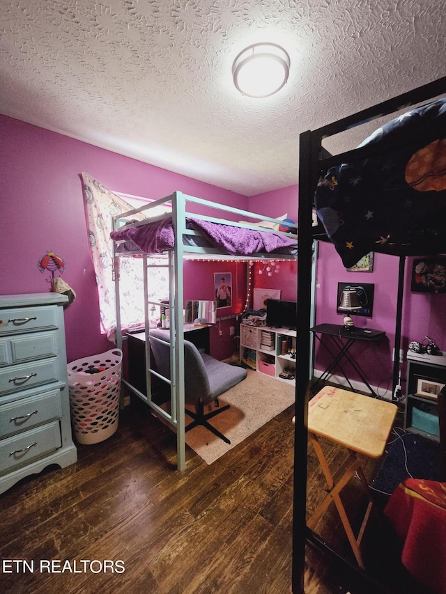 bedroom featuring dark wood-type flooring and a textured ceiling