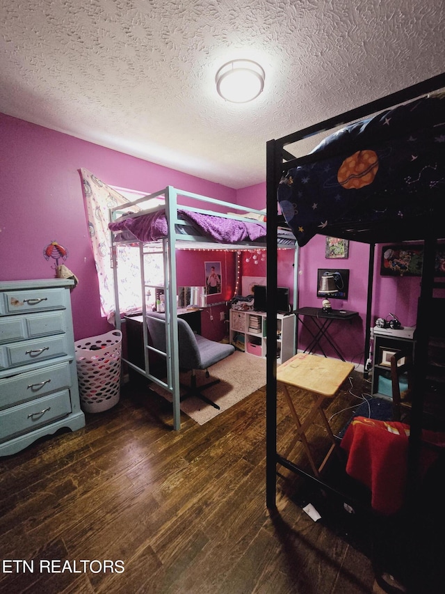 bedroom featuring a textured ceiling and hardwood / wood-style floors