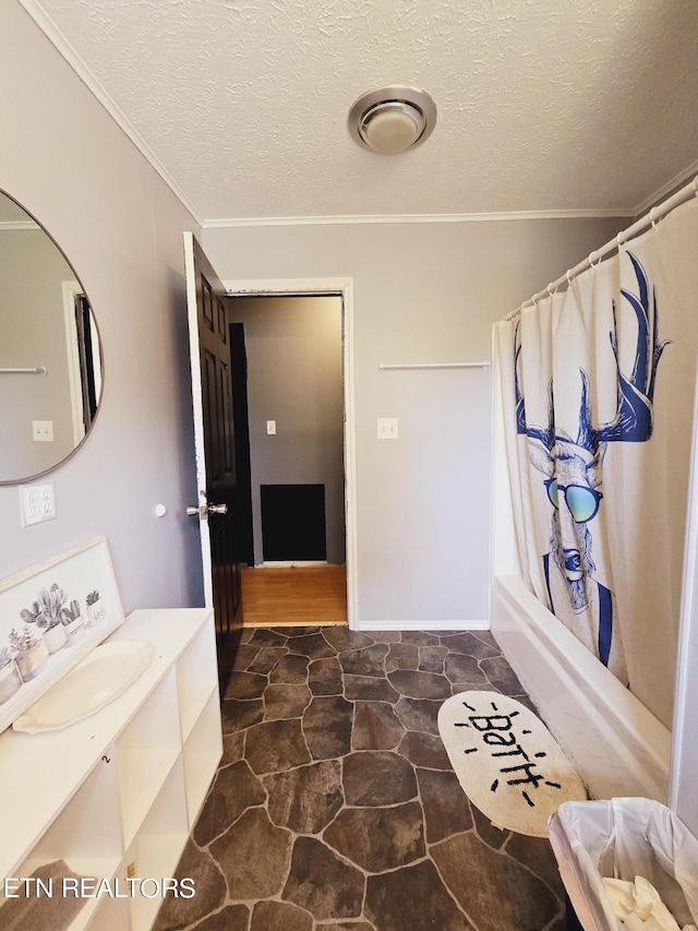 bathroom with a textured ceiling, ornamental molding, vanity, and shower / tub combo with curtain