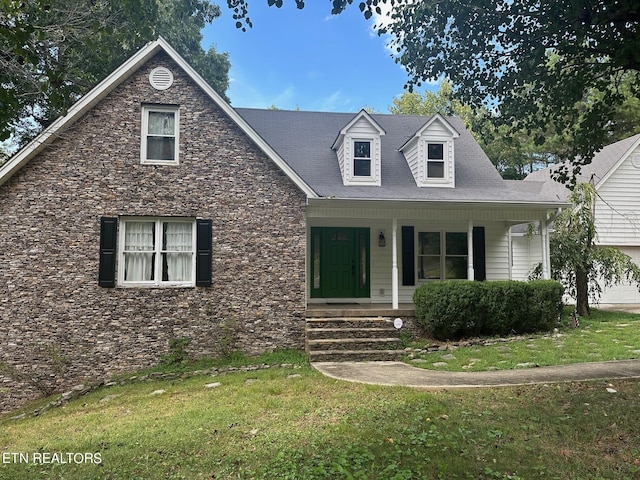 new england style home featuring a front lawn and a porch