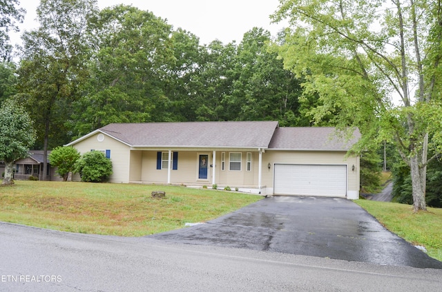 ranch-style house featuring covered porch, a front yard, and a garage