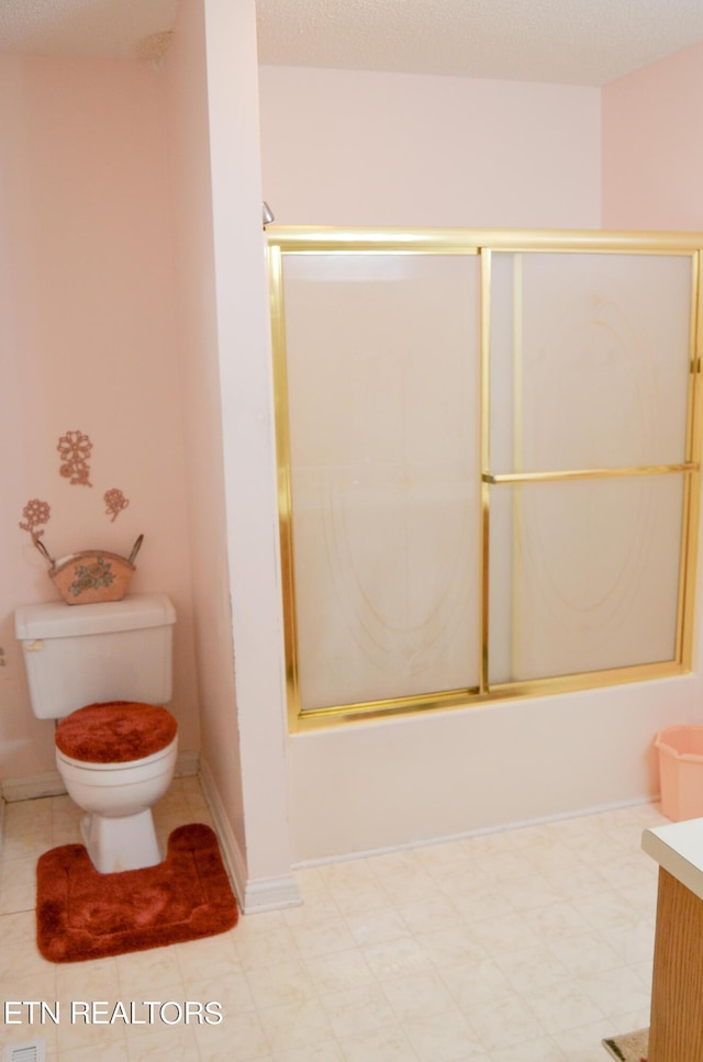 full bathroom featuring vanity, bath / shower combo with glass door, and toilet