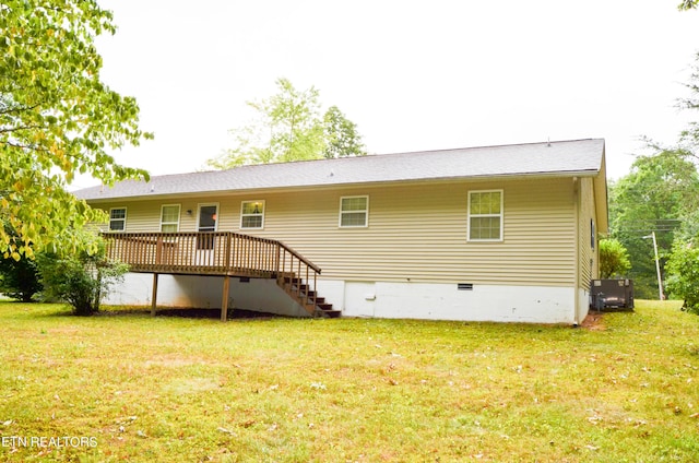 rear view of property featuring a lawn and a wooden deck