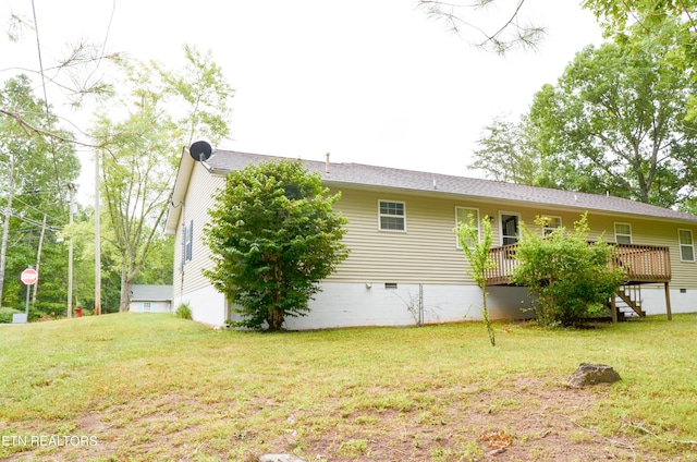 rear view of property featuring a yard and a wooden deck