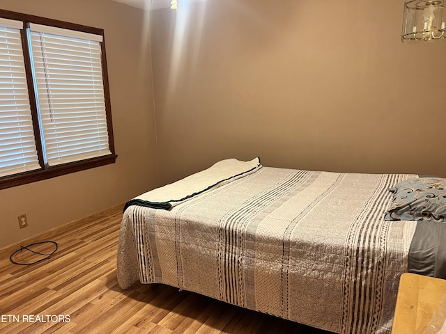 bedroom featuring a chandelier and light hardwood / wood-style floors