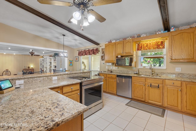 kitchen featuring sink, light stone countertops, hanging light fixtures, and appliances with stainless steel finishes