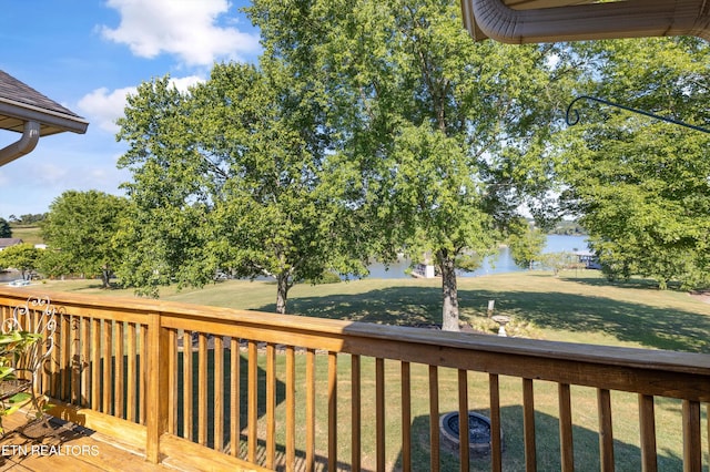 wooden terrace with a yard and a water view