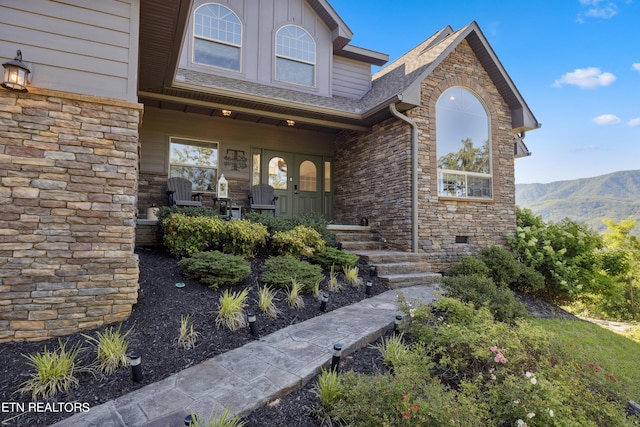 doorway to property featuring a porch and a mountain view