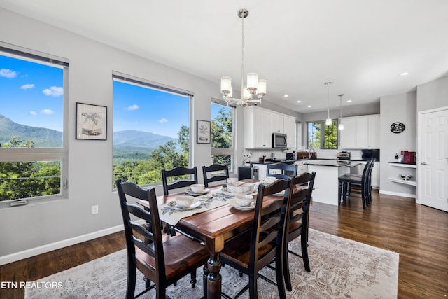 dining area featuring a mountain view, dark hardwood / wood-style flooring, and a chandelier