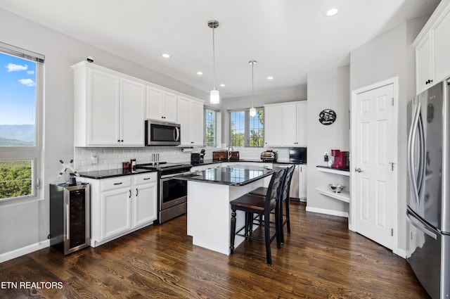 kitchen with white cabinets, appliances with stainless steel finishes, and a kitchen island