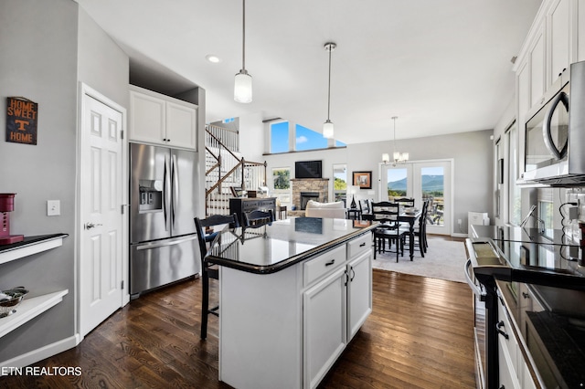 kitchen featuring appliances with stainless steel finishes, white cabinetry, a breakfast bar, and a kitchen island