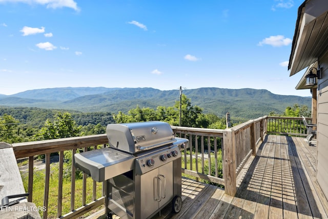 wooden deck with a mountain view and grilling area