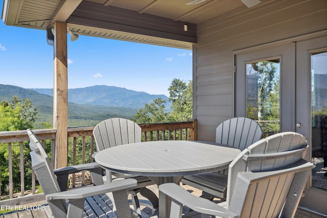 view of patio with ceiling fan and a deck with mountain view